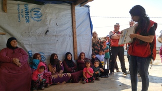 レバノン赤十字社スタッフの話に熱心に耳を傾けるシリア難民
