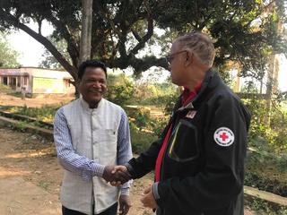 赤十字職員と地区長（左）が固い握手を交わす