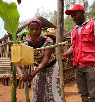 ルワンダ赤十字社の活動で設置した足踏式手洗い場で手を洗う村の女性