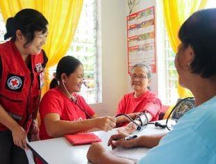 フィリピンの診療所で活動する地域保健ボランティアと日赤保健要員
