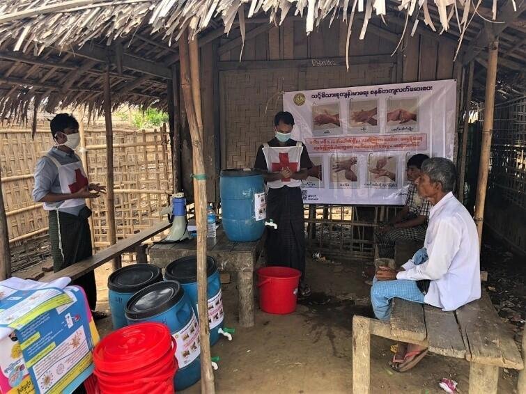 COVID19感染拡大を防ぐために国内避難民キャンプで正しい手洗い方法を伝える赤十字スタッフ（ミャンマー）