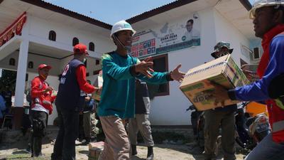 救援物資を運ぶインドネシア赤の職員とボランティア
