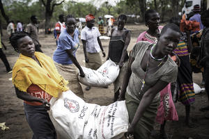 ICRCから供給されたかぼちゃの種を運ぶ女性たち